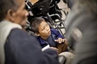 Refugee child by wheelchair