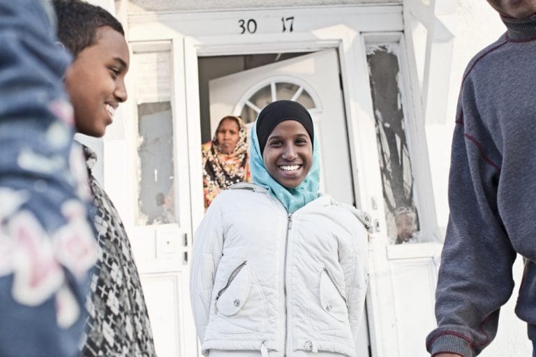 Somali refugee family outside of their home
