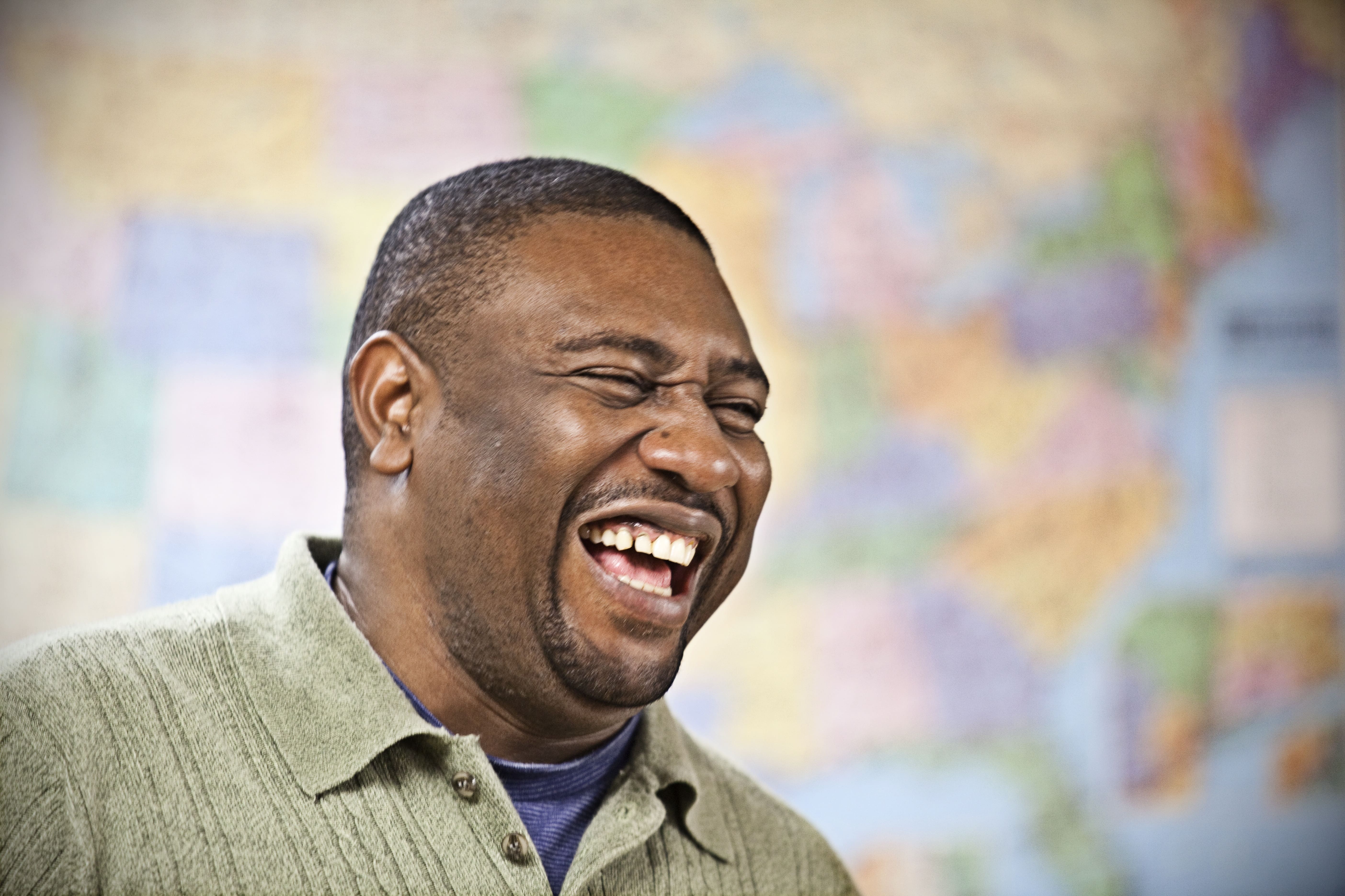 Man Smiling in front of Map of US