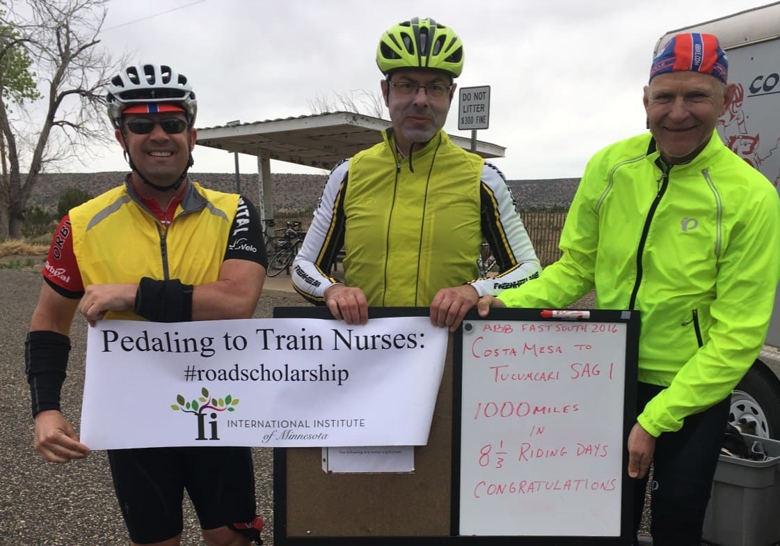 Jeff and two bikers hold sign reading "pedaling to train nurses"