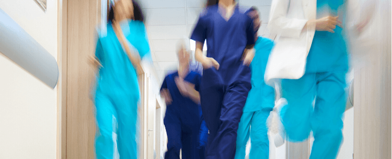 Unfocused photo of people in scrubs rushing