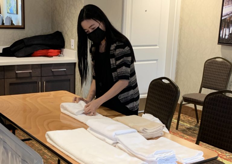 Housekeeping student practices folding hotel towels