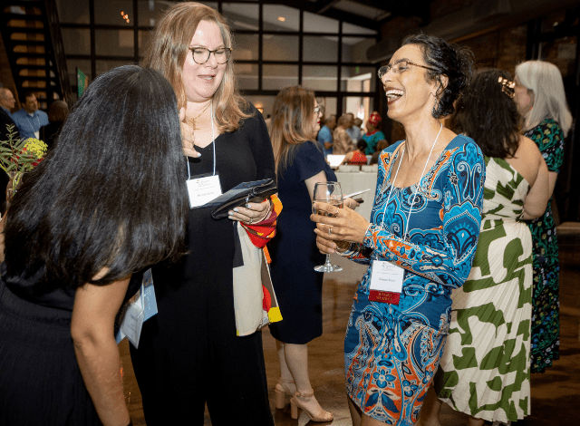 Women talk and laugh at an event