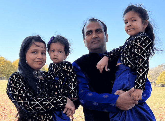 A Nepali mother and father hold their two daughters